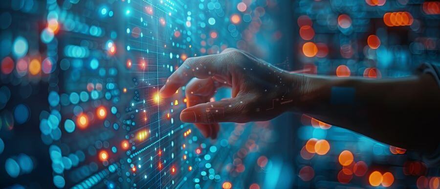 A man's hand touching a computer screen that shows data points.